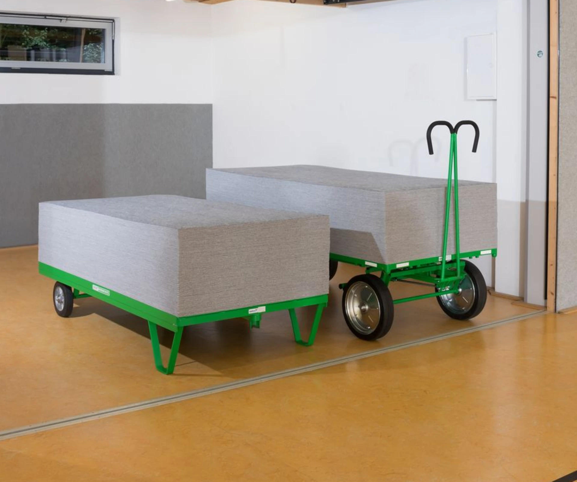 Zwei Transportwagen mit gestapelten Schutzplatten in der Halle